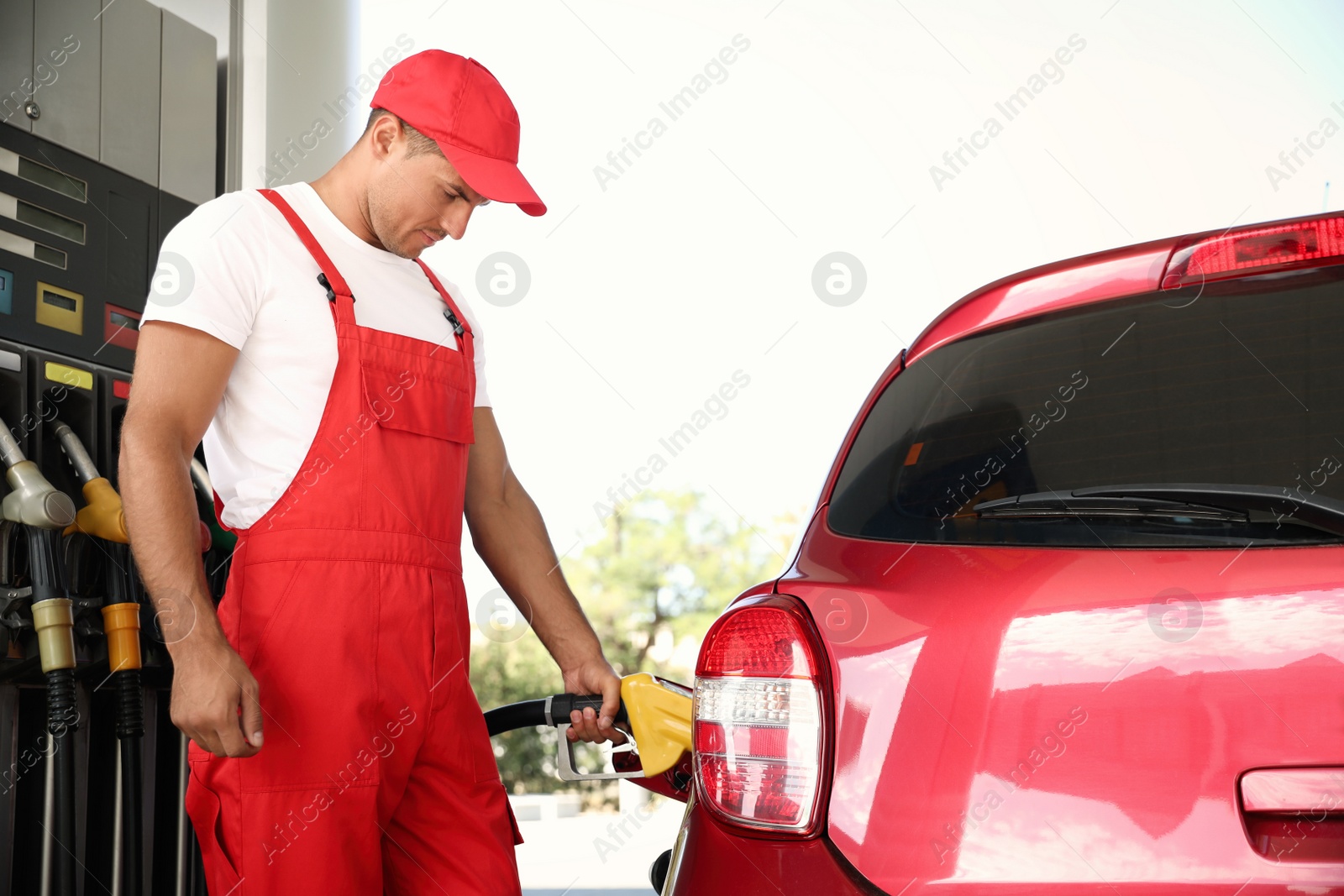 Photo of Worker refueling car at modern gas station