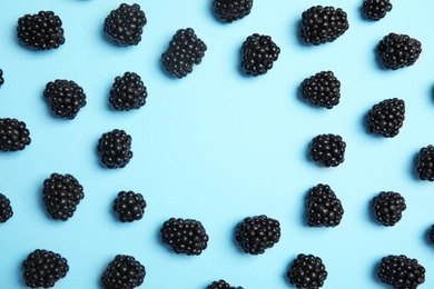 Flat lay composition with ripe blackberries on color background