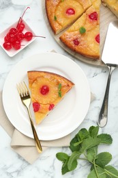 Delicious cut pineapple pie with cherry and mint on white marble table, flat lay