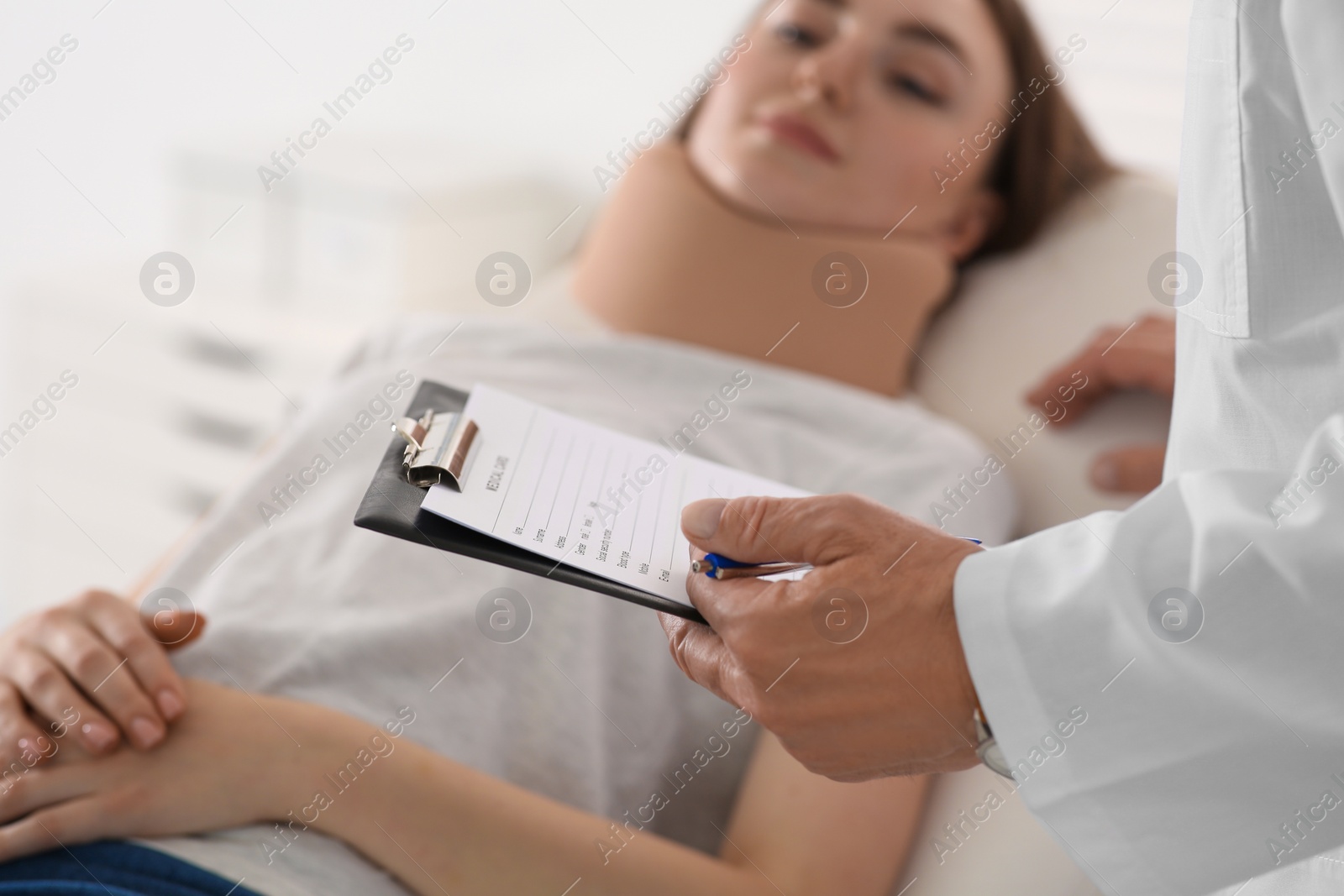 Photo of Orthopedist examining patient with injured neck in clinic, closeup