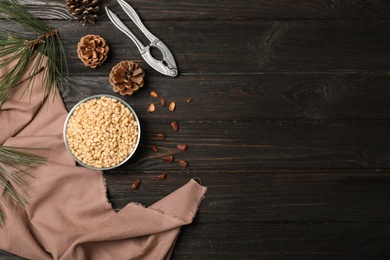 Photo of Flat lay composition with pine nuts on wooden background. Space for text