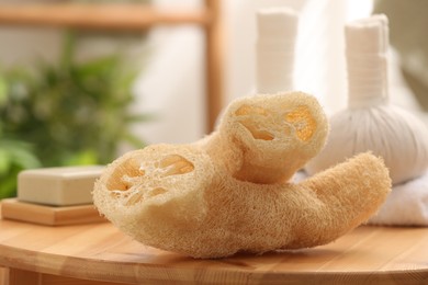 Photo of Loofah sponges on wooden table indoors, closeup