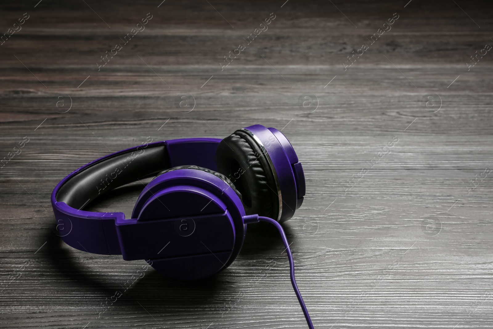 Photo of Stylish headphones on wooden background. Space for text