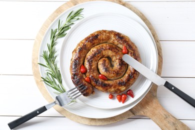 Photo of Tasty homemade sausages with peppers and rosemary served on white wooden table, top view