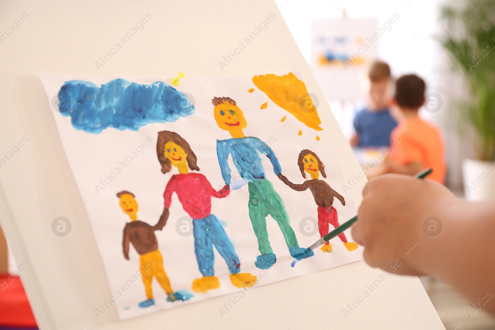 Photo of Little child painting family indoors, closeup view