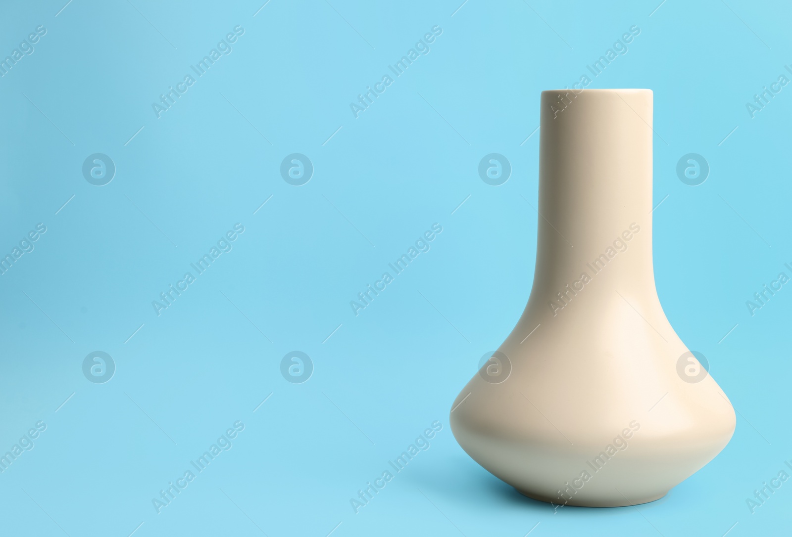 Photo of Stylish empty ceramic vase on light blue background, space for text