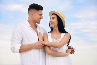 Happy young couple dancing outdoors in summer