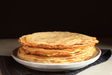 Stack of fresh thin pancakes on table