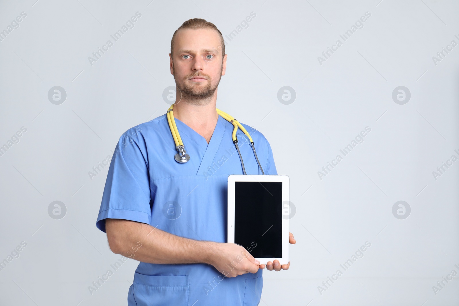 Photo of Portrait of medical assistant with stethoscope and tablet on color background. Space for text