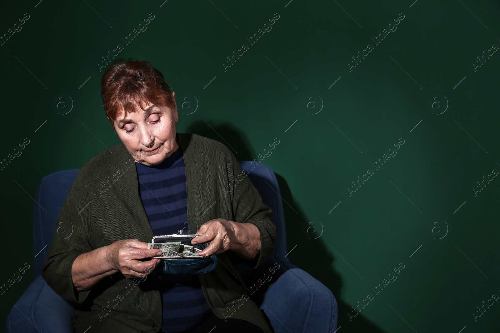 Photo of Poor senior woman with money on color background. Space for text