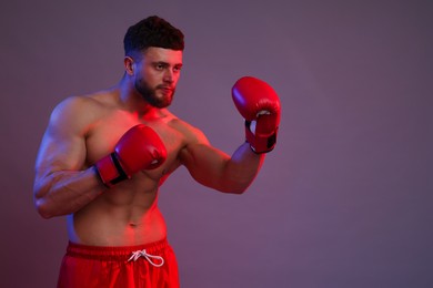 Photo of Man in boxing gloves fighting on color background. Space for text