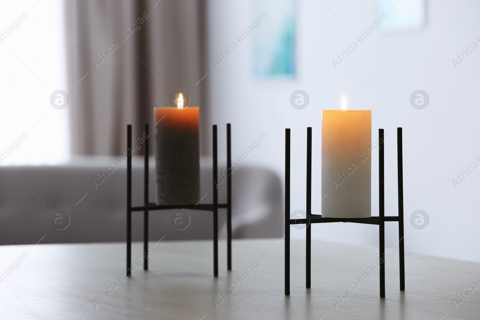 Photo of Burning candles on table in living room