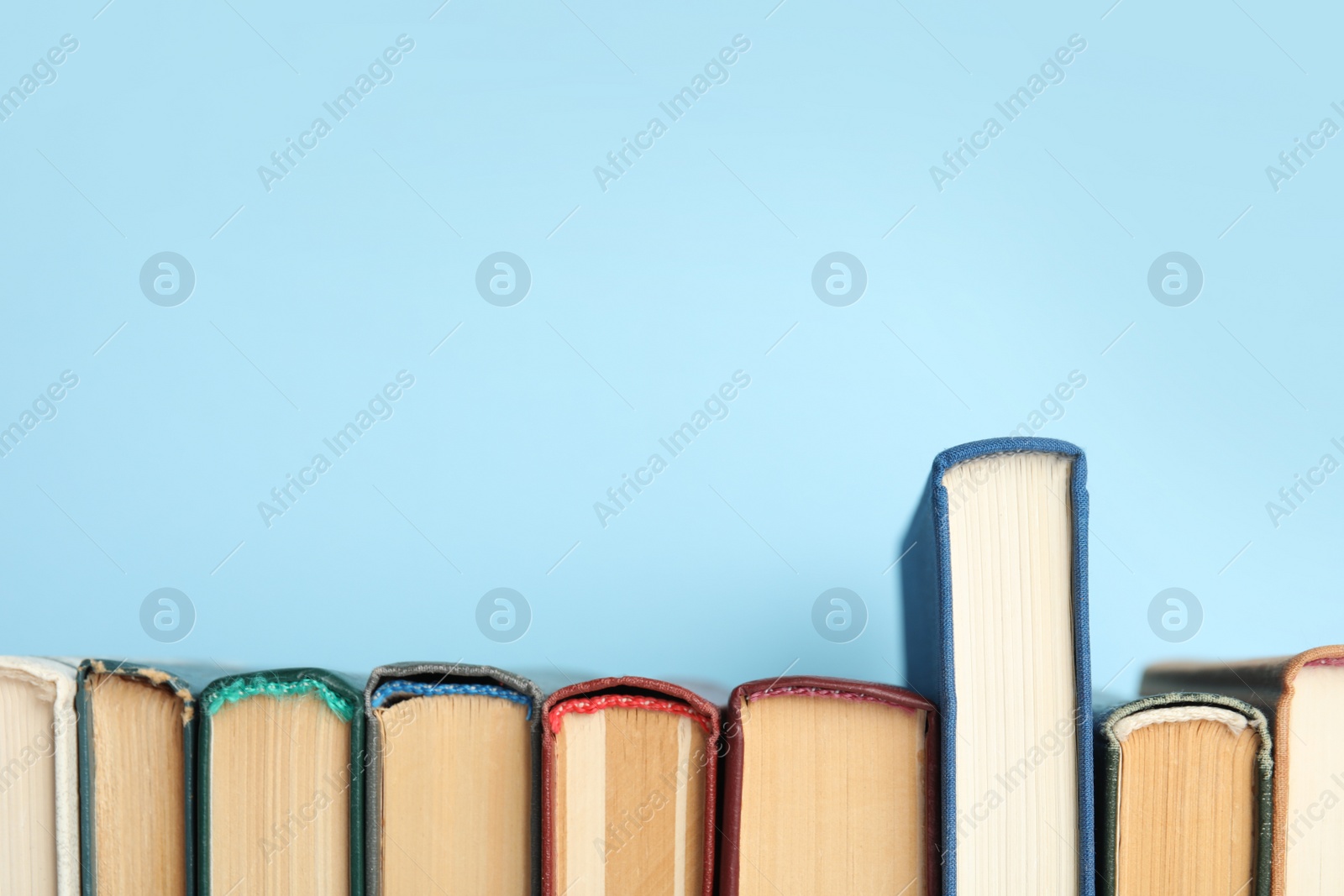 Photo of Collection of old books on light blue background. Space for text