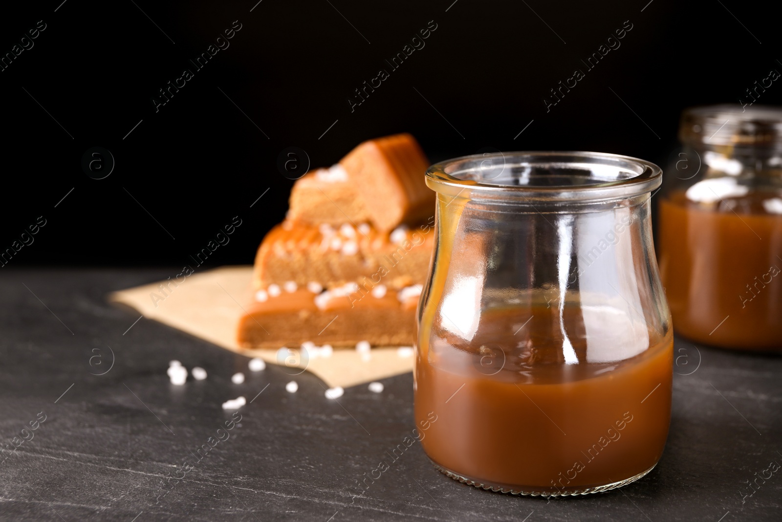Photo of Salted caramel in jar on grey table