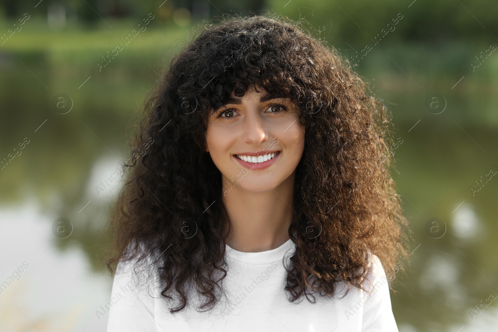 Photo of Portrait of beautiful woman posing on blurred background. Attractive lady smiling and looking into camera