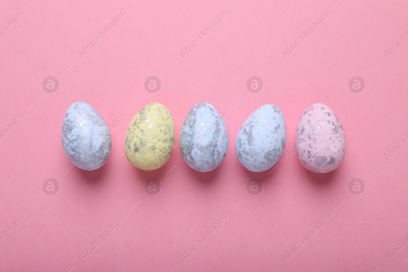 Photo of Many painted Easter eggs on pink background, flat lay