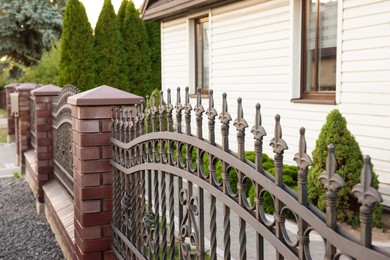 Beautiful brick fence with iron railing outdoors