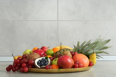 Assortment of fresh exotic fruits on grey table. Space for text