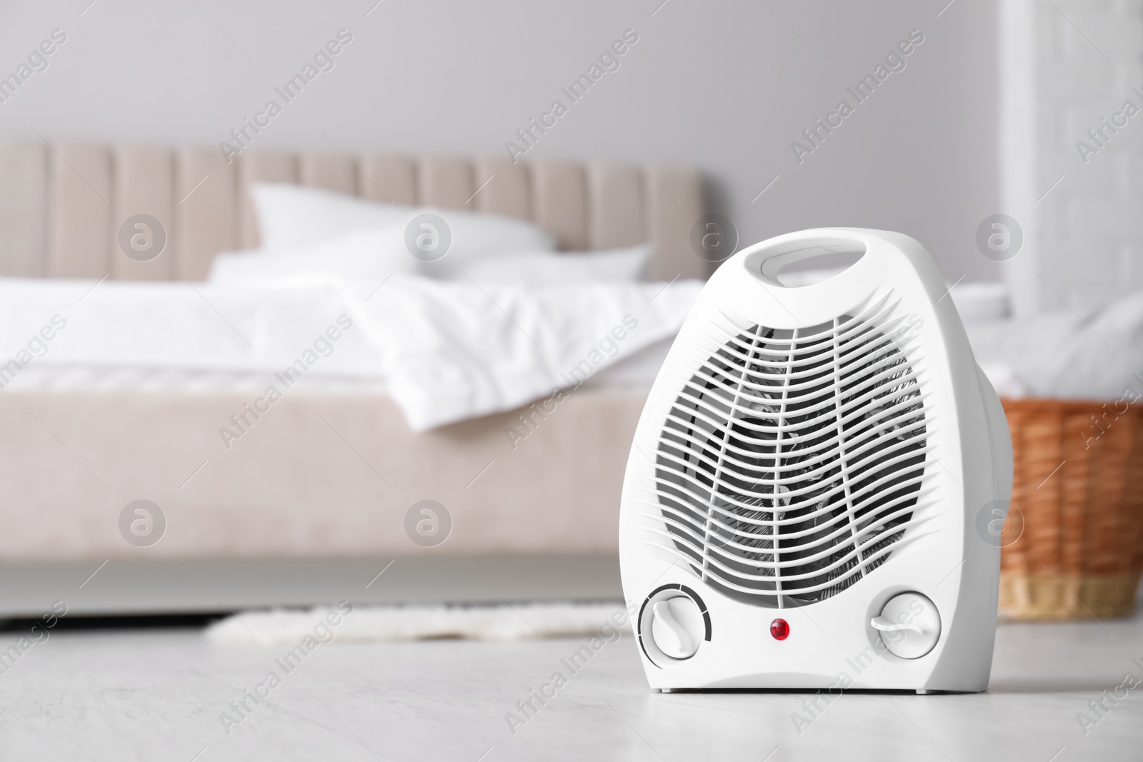 Photo of Modern electric fan heater on floor in light bedroom. Space for text