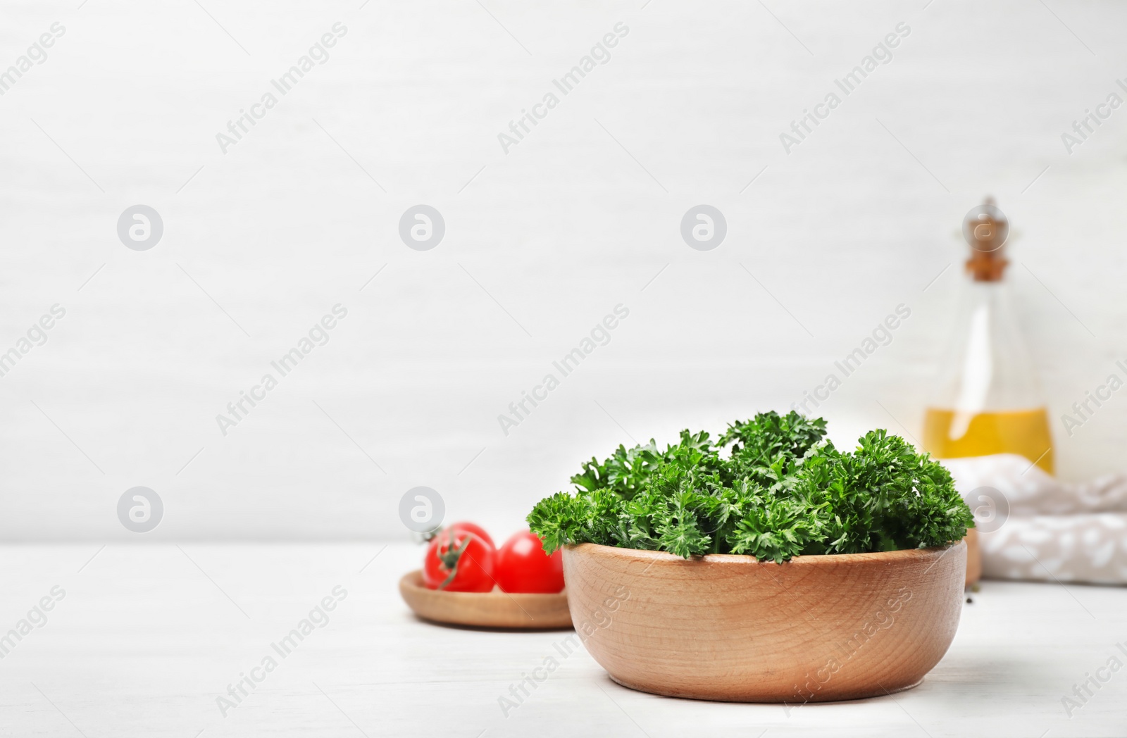 Photo of Bowl with fresh green parsley on table