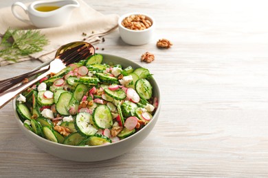 Photo of Delicious cucumber salad served on white wooden table. Space for text