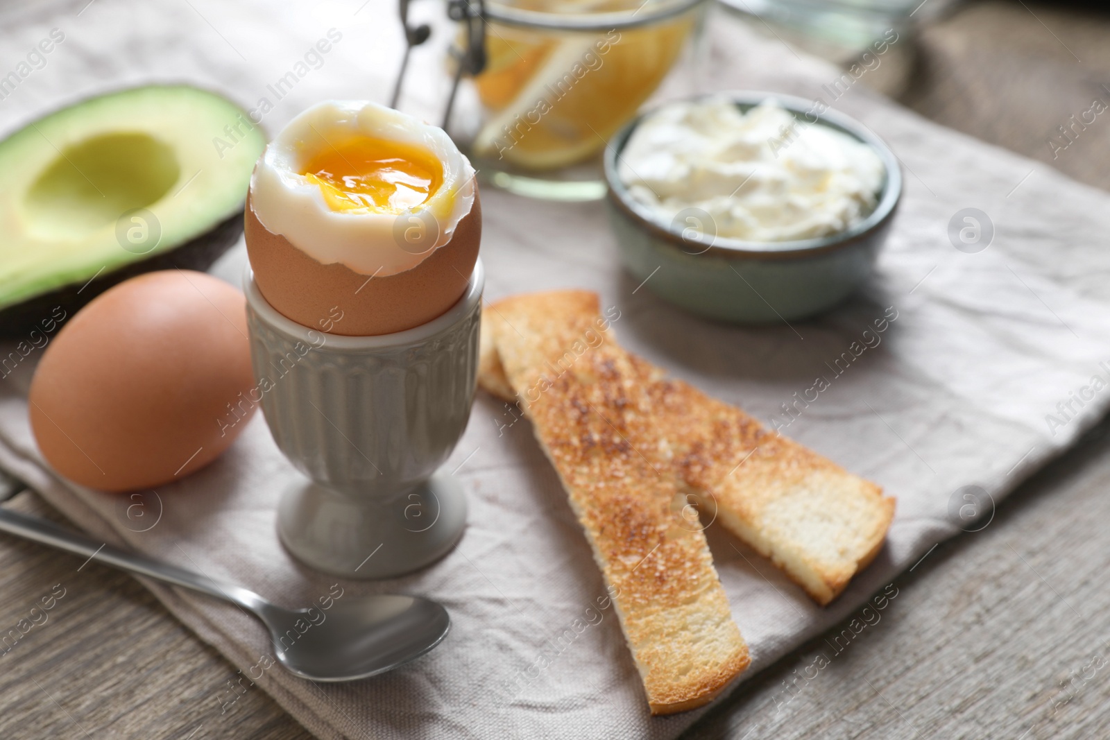 Photo of Soft boiled egg served for breakfast on wooden table