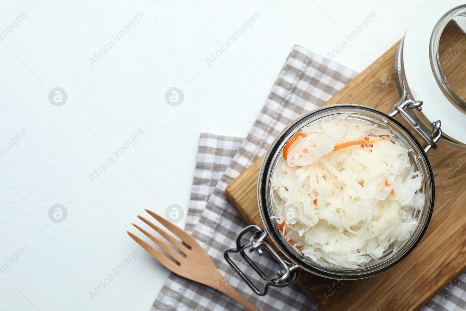 Photo of Tasty fermented cabbage on white table, flat lay. Space for text