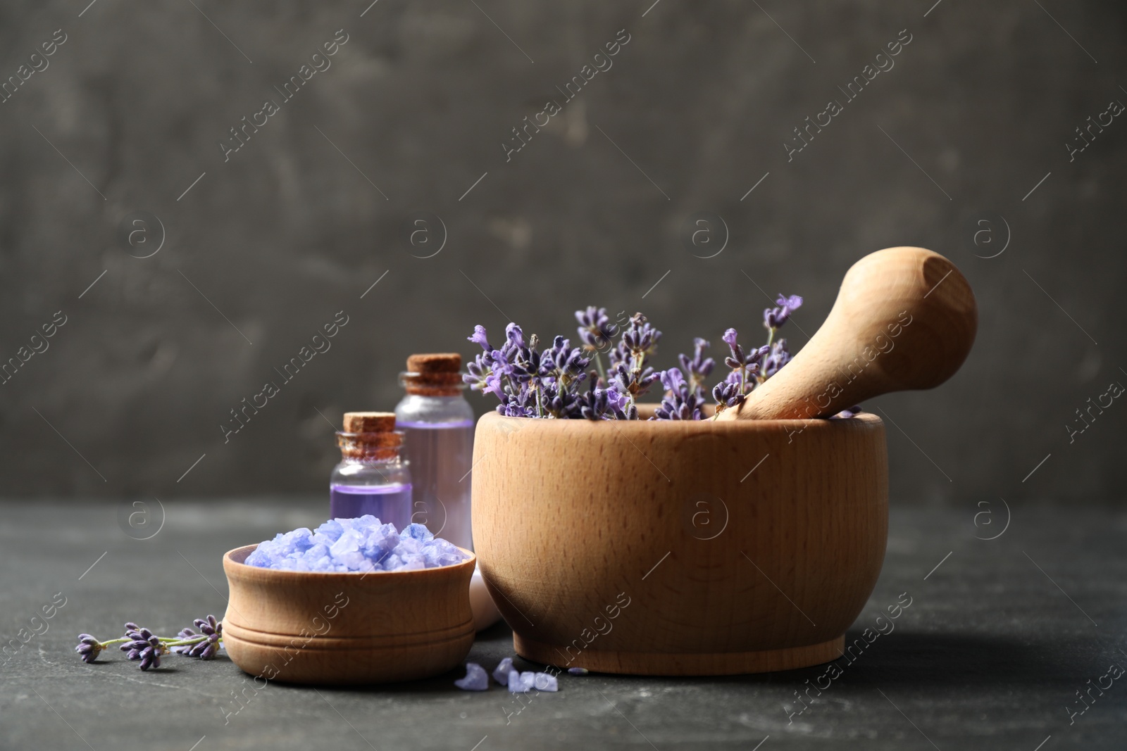 Photo of Cosmetic products and lavender flowers on dark grey background