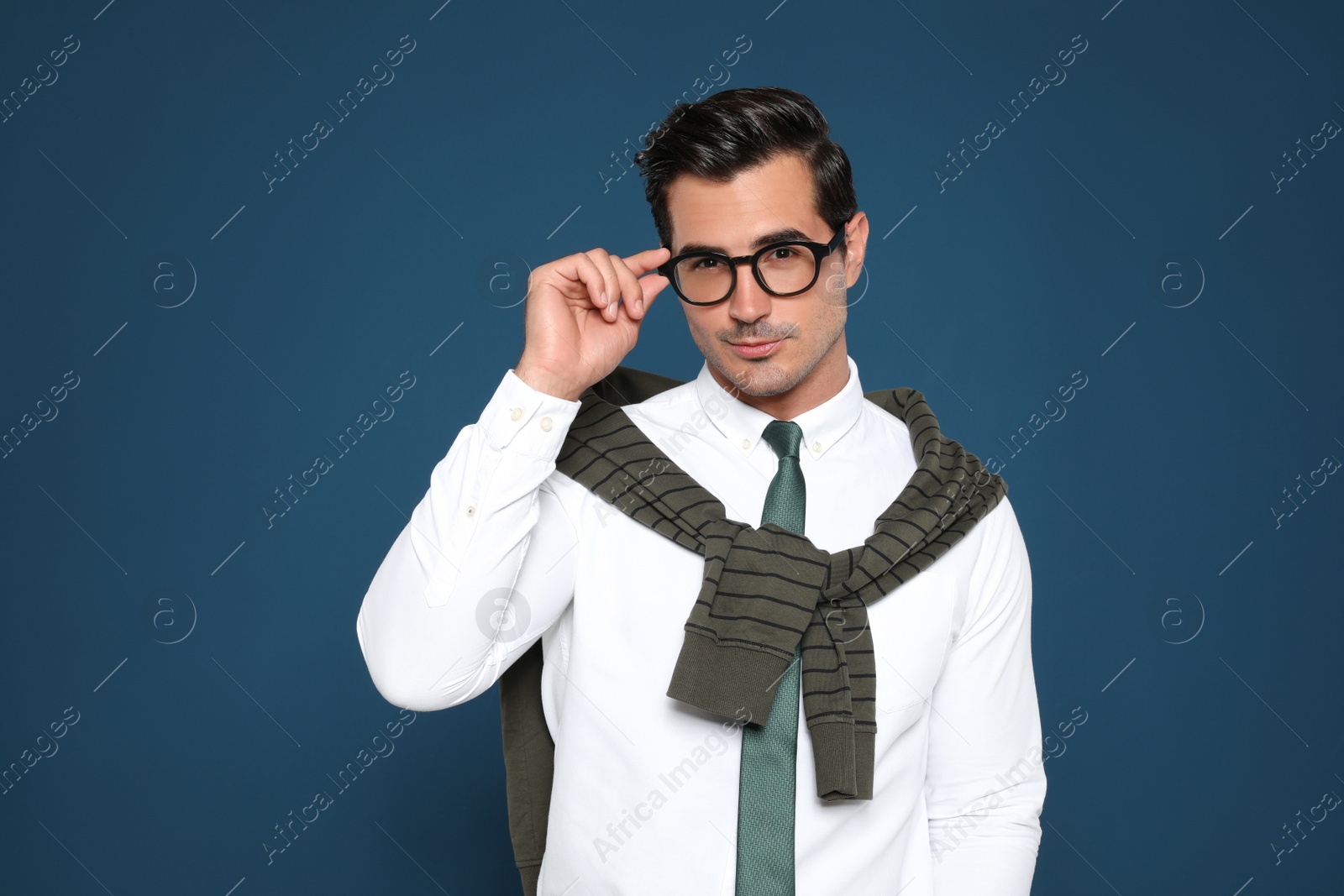 Photo of Portrait of handsome young man wearing glasses on blue background