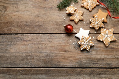 Tasty Christmas cookies and festive decor on wooden table, flat lay. Space for text