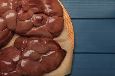 Photo of Fresh raw kidney meat on blue wooden table, top view. Space for text