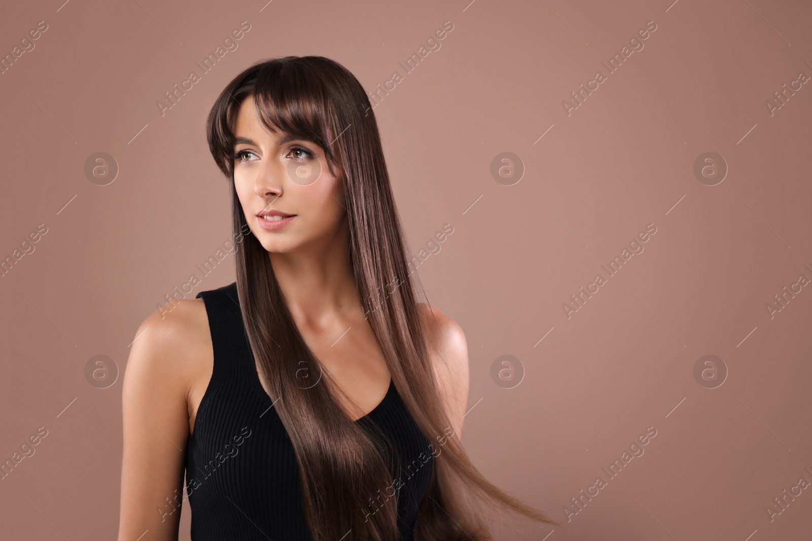 Image of Attractive woman with shiny straight hair on brown background, space for text. Professional hairstyling