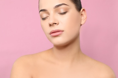 Portrait of young woman with beautiful face and natural makeup on color background, closeup