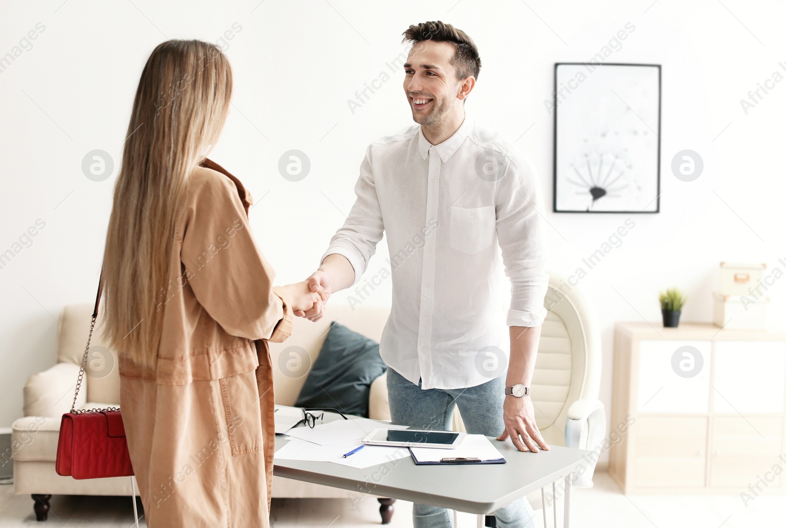Photo of Human resources manager shaking hands with applicant during job interview in office