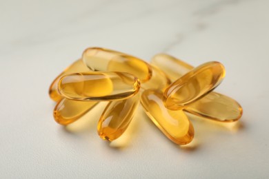 Photo of Dietary supplement capsules on white table, closeup