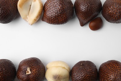 Frame of fresh salak fruits on white background, flat lay. Space for text