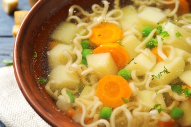 Photo of Bowl of fresh homemade vegetable soup on table, closeup