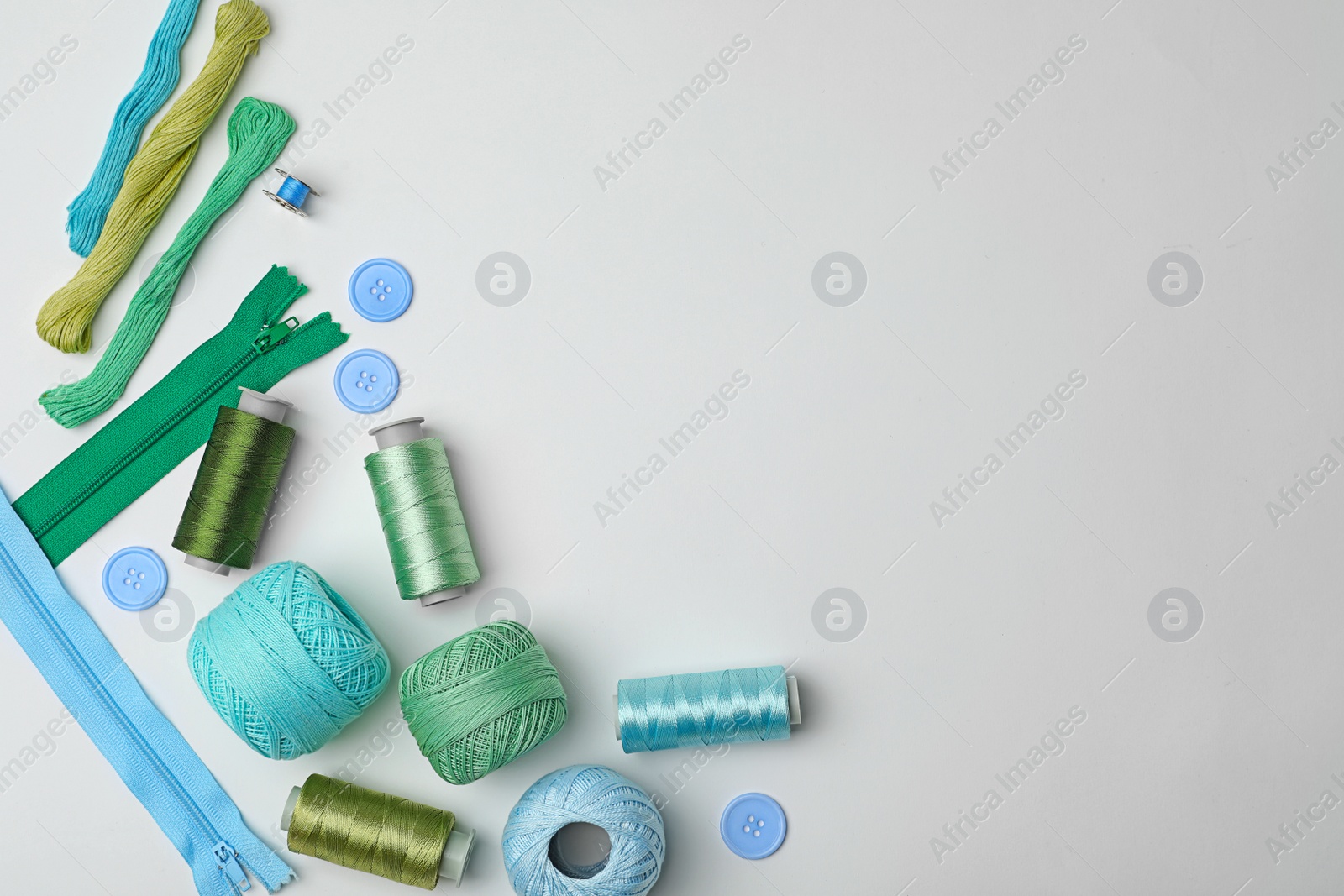 Photo of Composition with color sewing threads on white background, top view