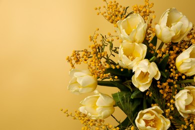 Photo of Bouquet with beautiful tulips and mimosa flowers on yellow background, top view. Space for text