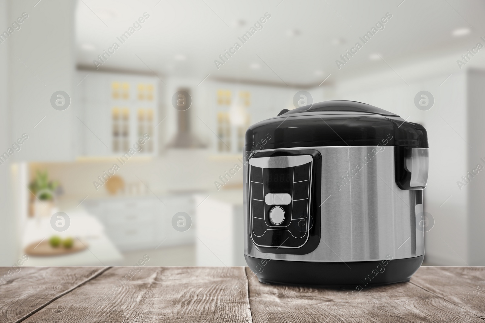 Image of Modern electric multi cooker on wooden table in kitchen. Space for design