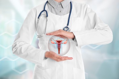 Doctor demonstrating virtual icon with illustration of female reproductive system on light background, closeup. Gynecological care 