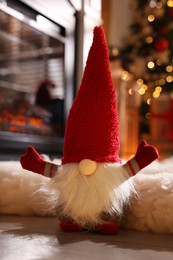 Cute Christmas gnome on floor in room with festive decorations