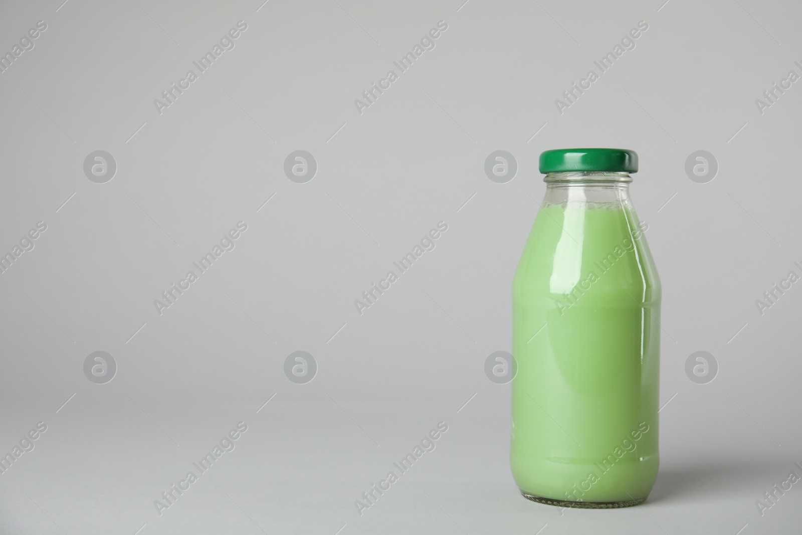 Photo of One bottle with tasty drink on color background. Space for text