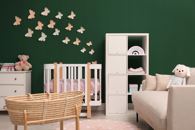 Beautiful baby room interior with stylish furniture and wicker cradle