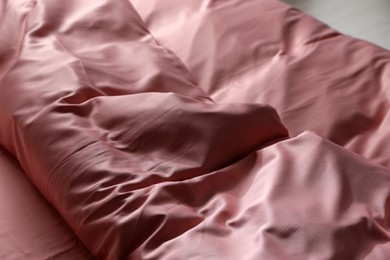 Photo of Closeup view of bed with beautiful pink silk linens