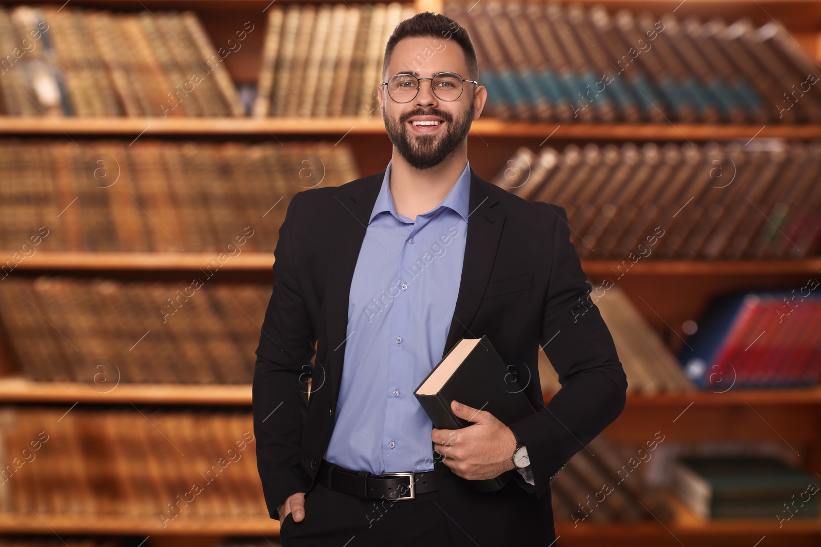 Image of Successful lawyer in glasses against shelves with books