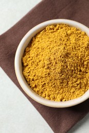 Photo of Curry powder in bowl on white table, top view