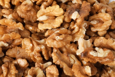 Photo of Many shelled walnuts as background, top view