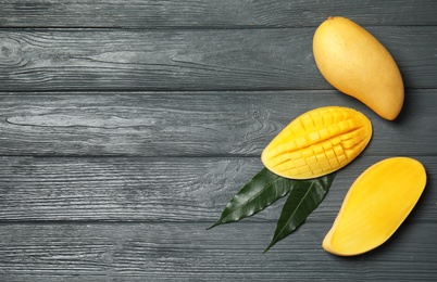 Photo of Flat lay composition with mango on wooden background. Space for text