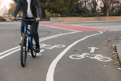Photo of Man riding bicycle on lane in city, closeup